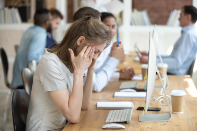 a person closing their ears at the office desk